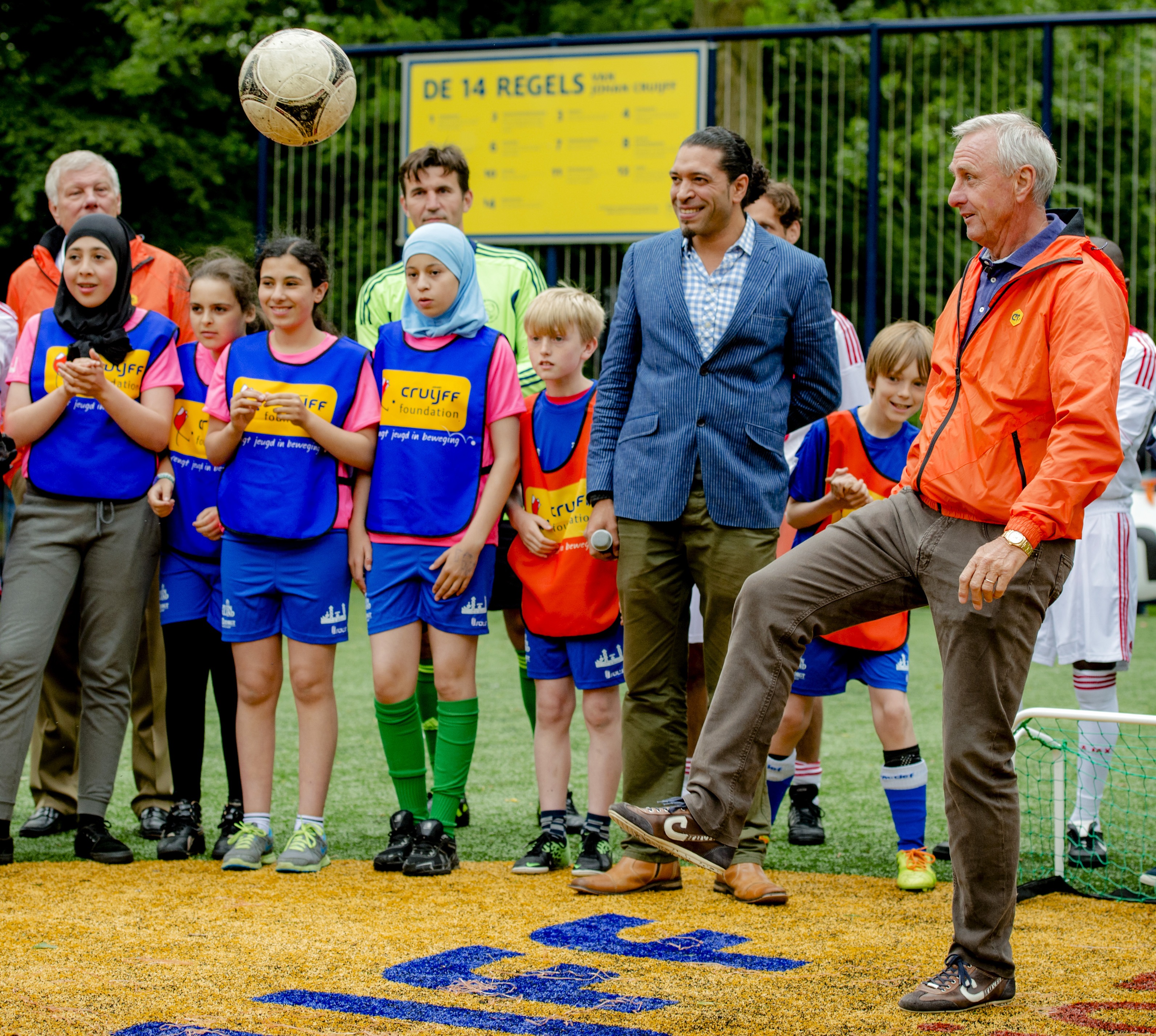 La leyenda holandesa Johan Cruyff (D) juega fútbol con niños en Amsterdam en Junio 5 del 2014. La Fundacion Cruyff ayuda a la municipalidades a crear campos de juego de fútbol. Foto AFP/R. van Lonhuijsen