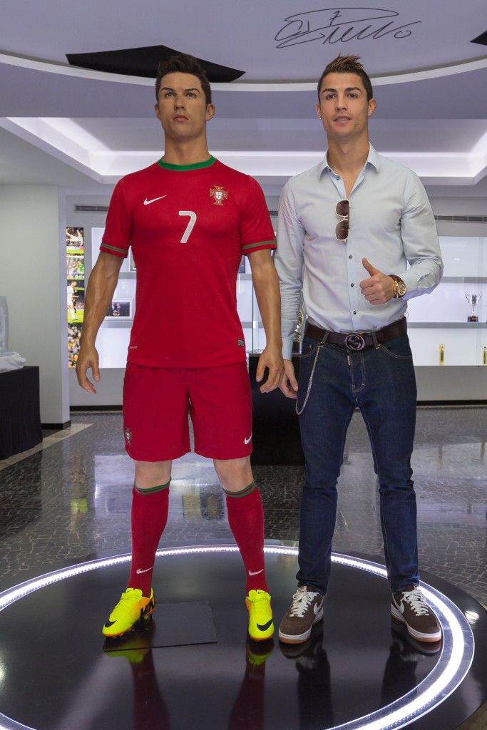 Portugese footballer and current country captain Christiano Ronaldo (R) poses beside a wax statue of himself during a the inauguration of the CR7 museum dedicated his professional career, in Madeire on December 15, 2013. "I wanted to make a museum for my fans, a place where they can admire the trophies I got during eleven years of professional "career, said Ronaldo at the inauguration of this space. AFP PHOTO / GREGORIO CUNHA
