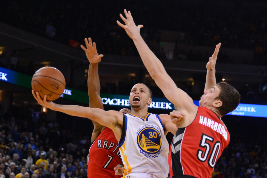 December 3, 2013; Oakland, CA, USA; Golden State Warriors point guard Stephen Curry (30) drives to the basket against Toronto Raptors point guard Kyle Lowry (7) and power forward Tyler Hansbrough (50) during the fourth quarter at Oracle Arena. The Warriors defeated the Raptors 112-103. Mandatory Credit: Kyle Terada-USA TODAY Sports