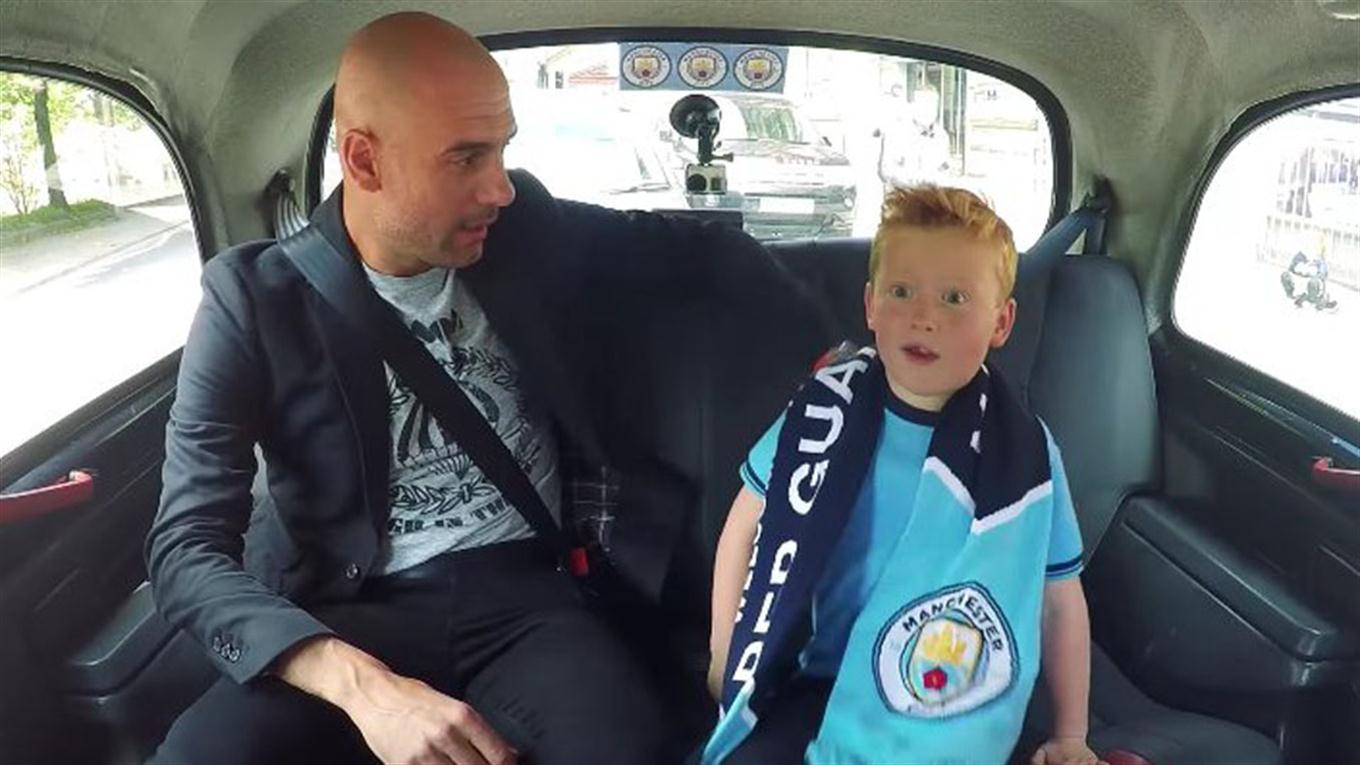 Pep Guardiola se pasea en Manchester con un pequeño fan del City