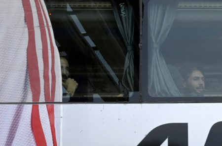 Los futbolistas Javier Pinola (I) y Germán Lux se observan en las ventanas del autobús que traslada al plantel de River Plate al aeropuerto de Ezeiza. Foto AFP