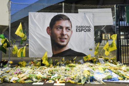 Flores, mensajes y velas colocados frente a un retrato gigante del desaparecido delantero argentino de Nantes