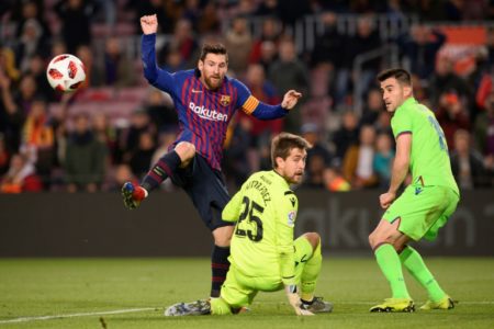 Lionel Messi disputa un balón con el portero y otro jugador del Levante