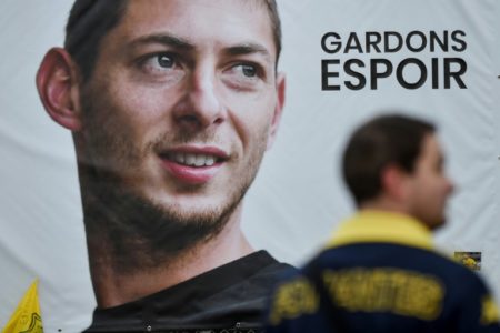 Un hombre se para frente a un retrato gigante del delantero argentino de Nantes, Emiliano Sala