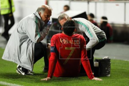 Cristiano Ronaldo (c) de Portugal recibe asistencia médica durante un partido