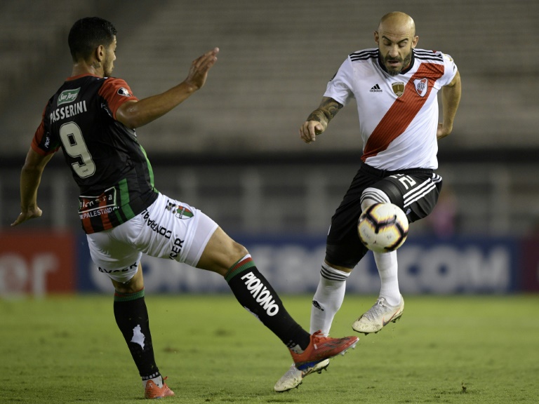 Javier Pinola (D), de River Plate, supera a Lucas Passerini (I), de Palestino