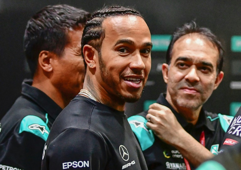 Lewis Hamilton sonríe en el pit del equipo