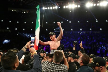 Canelo Álvarez posa con sus cinturones de campeón de los medianos y la bandera de México
