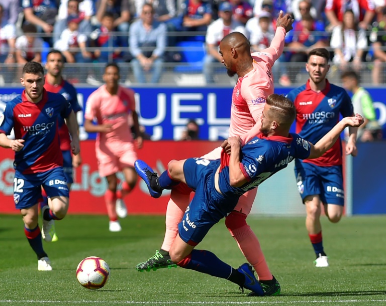 Jorge Pulido trata de quitar el balón al delantero visitante Kevin-Prince Boateng durante el partido liguero disputado entre Huesca y FC Barcelona