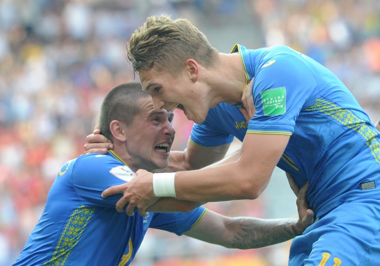 Vladyslav Supriaha (D) es felicitado por su compañero Viktor Korniienko tras anotar gol durante la final