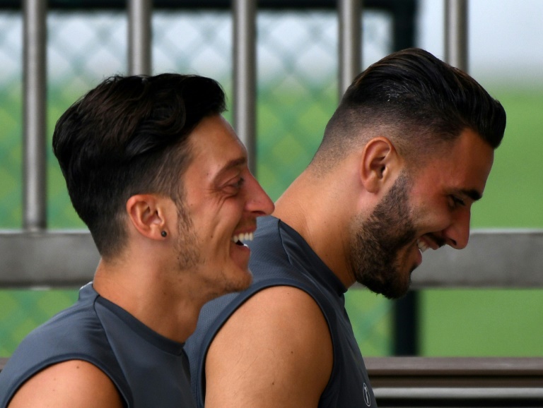 Mesut Ozil (izq) y Sead Kolasinac ríen a su llegada a un entrenamiento del Arsenal