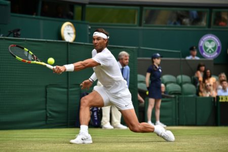 Rafael Nadal devuelve una bola de revés a Jo-Wilfried Tsonga durante el partido de tercera ronda del torneo de Wimbledon